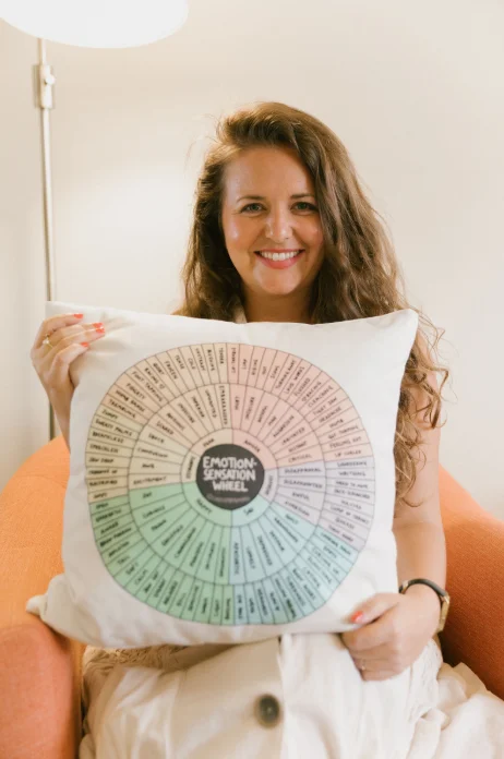 Melanie Gotez Therapist Holding Emotions Wheel Pillow